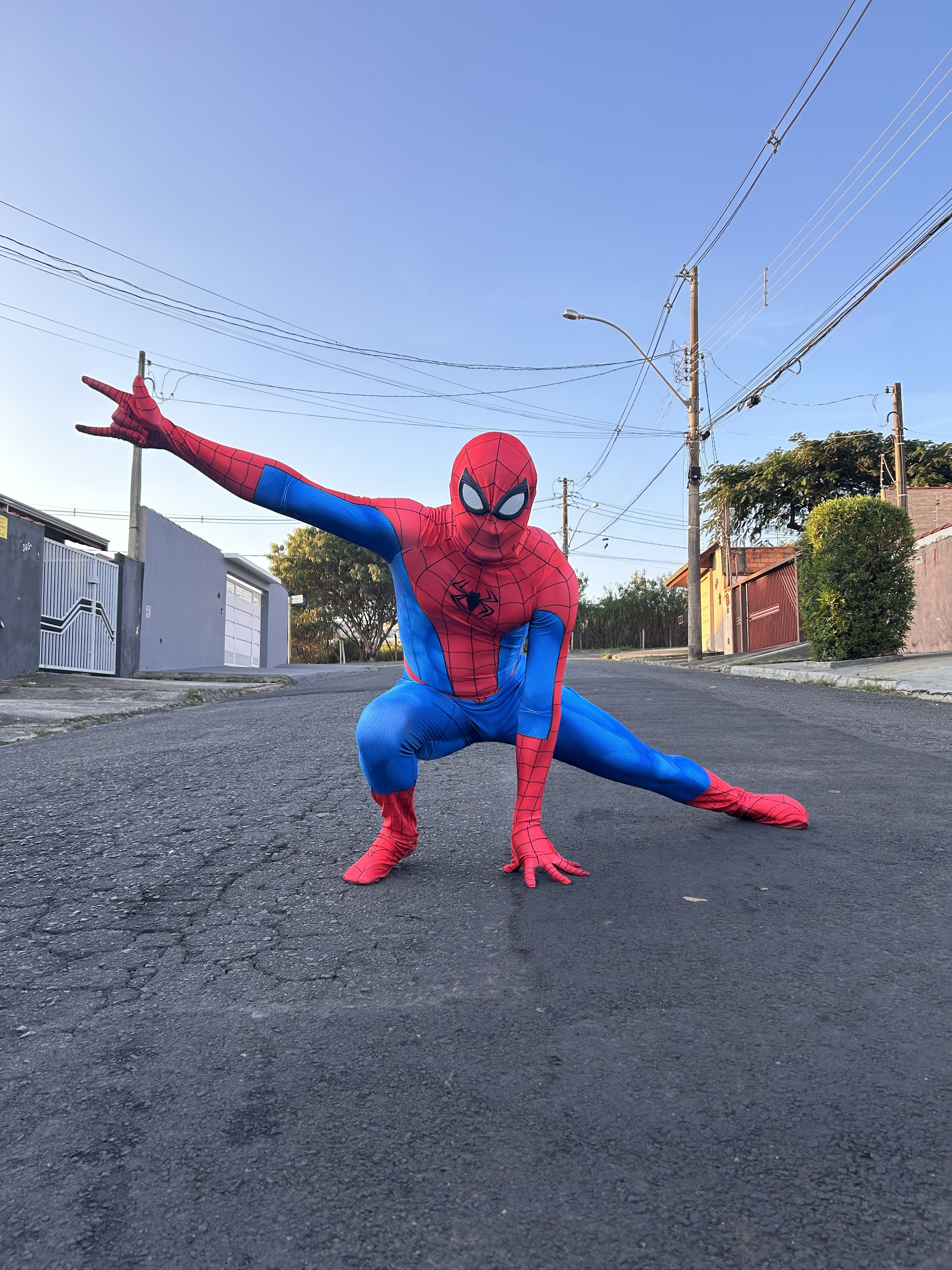 Personagem Homem-Aranha em pose de herói na rua